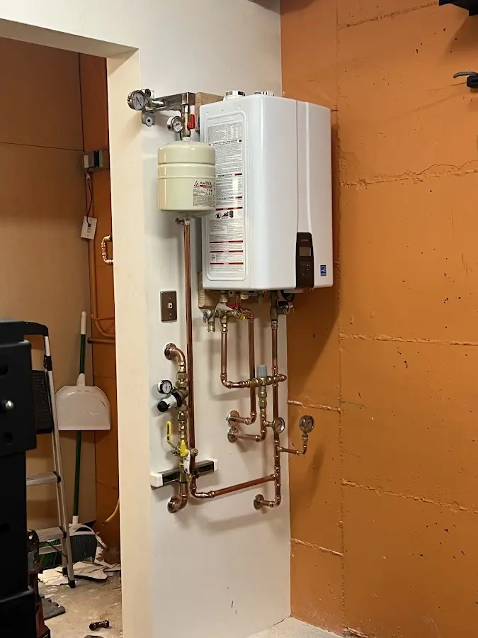 Plumbing technician inspecting water heater connections in Kilauea